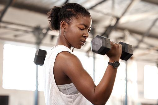 Foto de una joven deportista haciendo ejercicio con una mancuerna en un gimnasio photo
