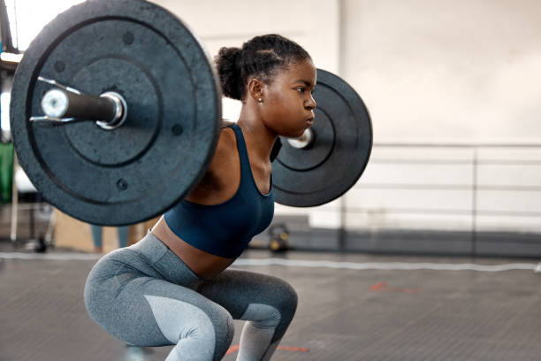 ujęcie sportowej młodej kobiety ćwiczącej ze sztangą na siłowni - barbell zdjęcia i obrazy z banku zdjęć