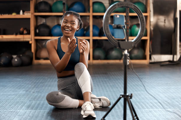 Shot of a sporty young woman recording herself while exercising in a gym I'll be sharing lots of workout tips with you all today vlogging stock pictures, royalty-free photos & images
