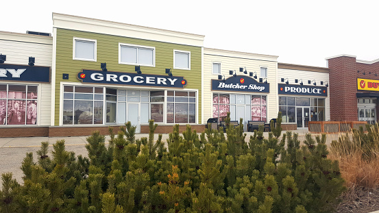 Langdon,Alberta, Canada- February 14,2022:  One Super Market with several exterior facades .  Creative exterior front for Buy Low Foods Supermarket in small town Langdon Alberta using old images from the past to show services.