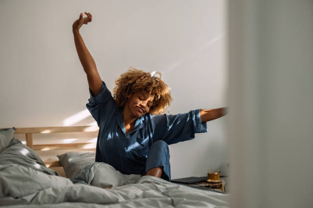 istock Beautiful Woman Waking Up and Stretching in Bed 1370783676