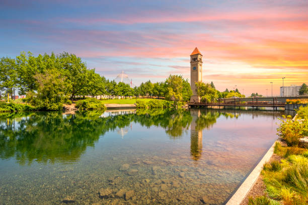 la torre dell'orologio di spokane e il padiglione lungo il fiume nel riverfront park, nel centro di washington, sotto un tramonto colorato a spokane, washington, usa - torre dellorologio foto e immagini stock