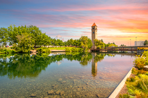 The Spokane Clock Tower and Pavilion along the river in Riverfront Park, downtown Washington, under a colorful sunset in Spokane, Washington, USA