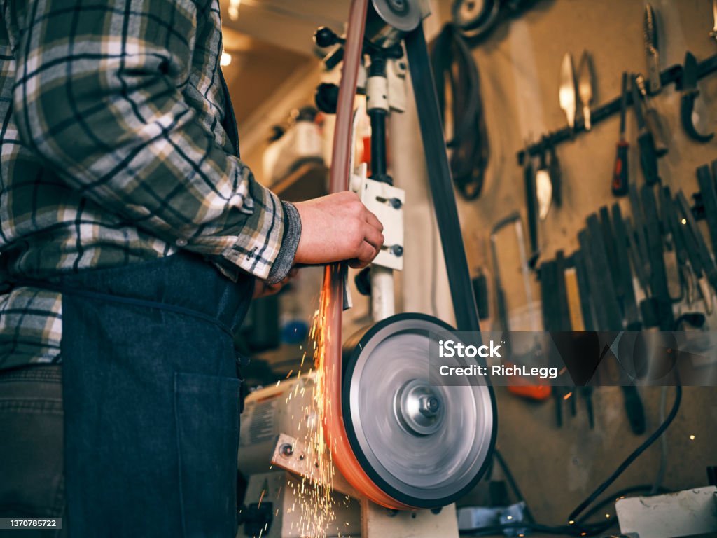 Home Forge Knife Making A man working in his home forge making knives. Blade Stock Photo