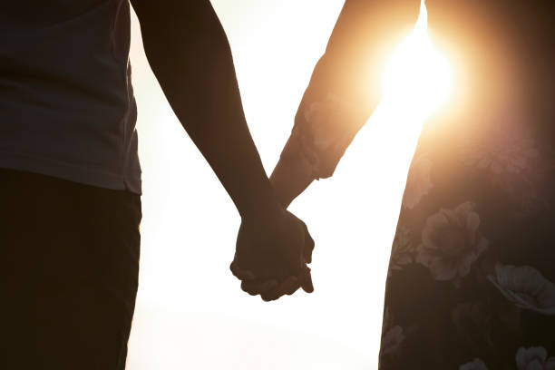 istock Shot of an unrecognizable couple holding hands while watching the sunset 1370786433