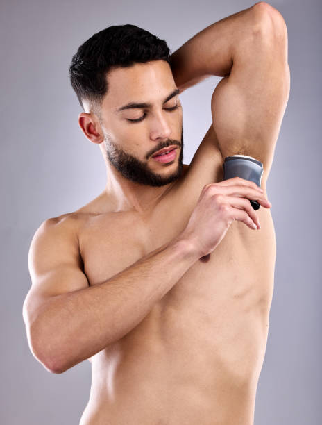 istock Shot of a handsome young man using a deodorant stick 1370790107