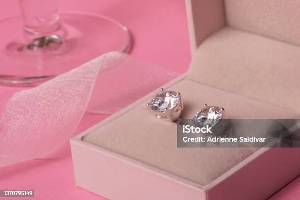 Diamond Earrings In Jewel Box With Champagne Glass And Ribbon On A Pink Background Stock Photo - Download Image Now