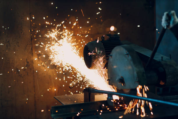 istock Metal processing with compound mitre saw with circular disk blade. Sparks in metalworking at factory. 1370800451