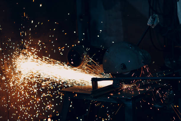 istock Metal processing with compound mitre saw with circular disk blade. Sparks in metalworking at factory. 1370800454