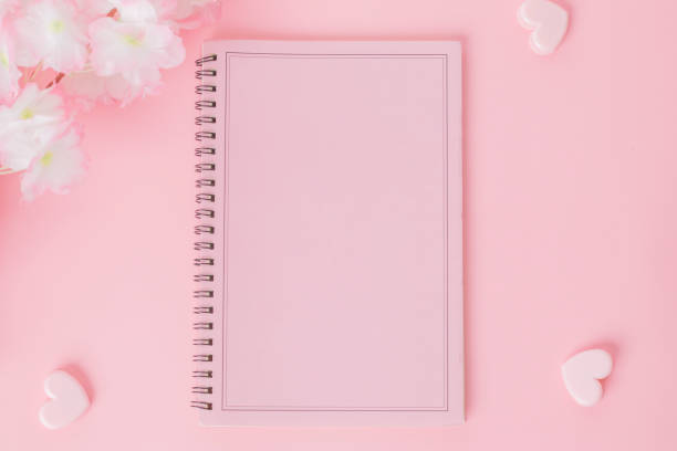 istock Pink notebook with flower on a pink background 1370810085