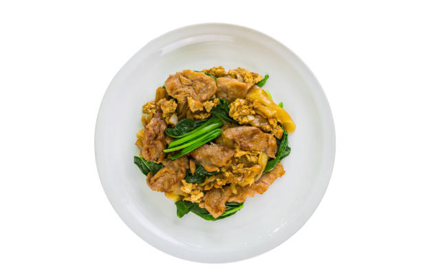 Above view of Stir-fried flat noodle and pork with dark soy sauce in plate isolated on white background. Pad See Ew Moo popular Asian traditional style. Thai food. Top-down