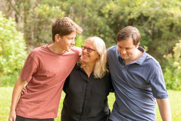 istock Mother hugging her teenage sons 1370814604