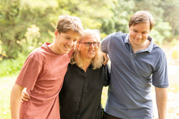 istock Mother hugging her teenage sons 1370814605