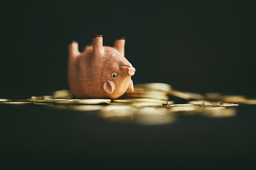 Lindo cerdo rosa al revés en una pila de monedas de oro. Enrollar en masa o dinero photo