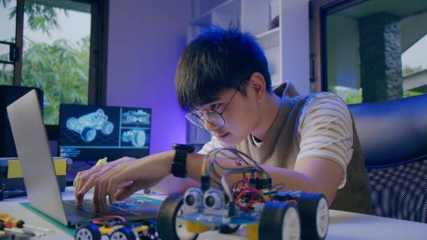 istock Asian teenager doing open-source hardware and software robot homework project in house 1370823435