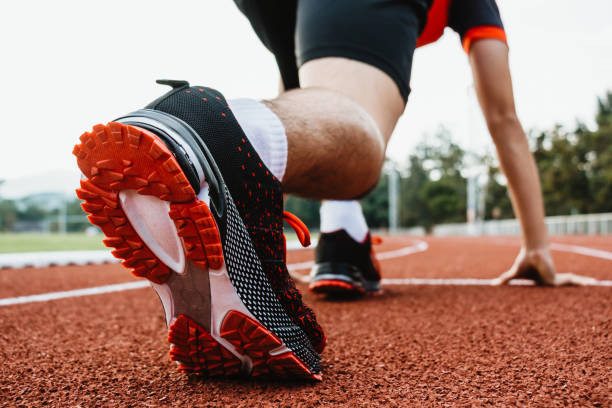 istock Male runner running on athletics track, closeup on shoe. 1370825923