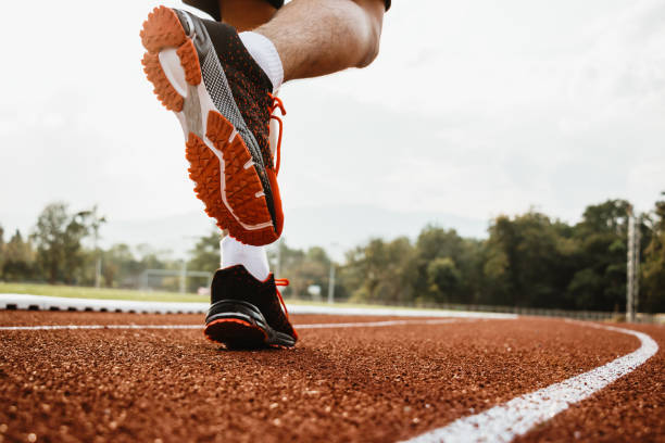 istock Male runner running on athletics track, closeup on shoe. 1370825932