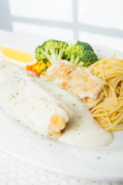 Fried fish fillets with rice and lemon on white plate