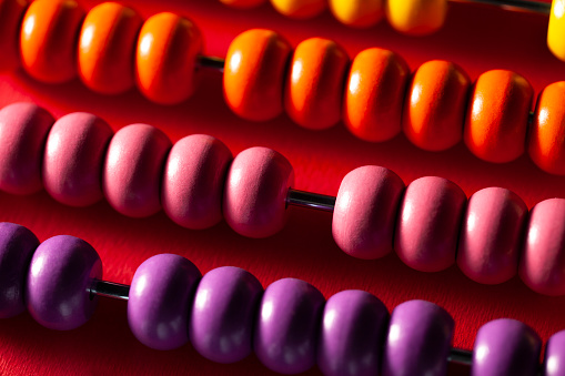 Abacus with colored beads on red background.
