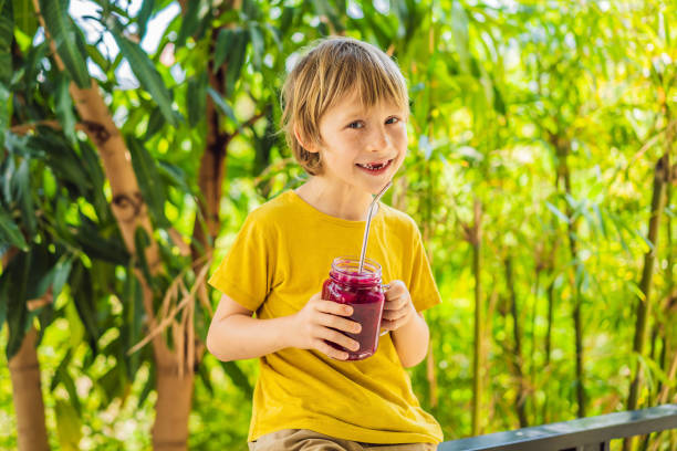 istock Boy holds smoothies from a dragon fruit with drinking straw 1370836472
