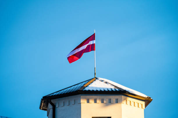 istock Latvian Flag on the flagpole fluttering in the wind against blue clear sky, copy space 1370837211
