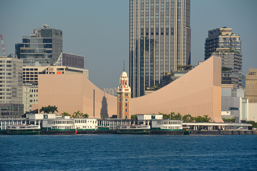 Pier of the famous Star ferry anf the iconic clock tower on Victoria Harbour, Tsim Sha Tsui district, Hong Kong.