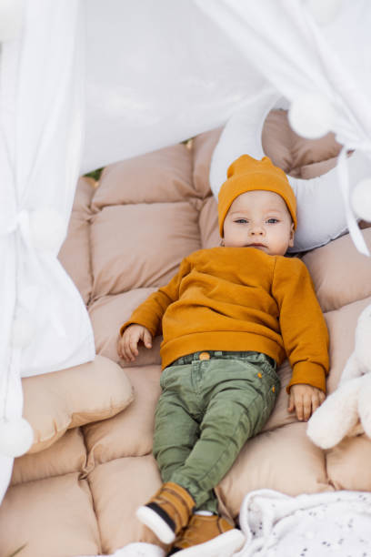 istock Relaxed toddler lying in wigwam on nature 1370842421
