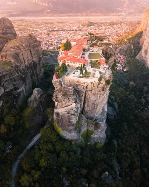 Atmospheric aerial top view of the Monastery of the Holy Trinity in Meteora. Tourist and pilgrimage inspiration backgrounds. Natural and religious wonders of Greece.