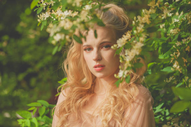 istock Attractive model woman in spring blossom trees 1370847336