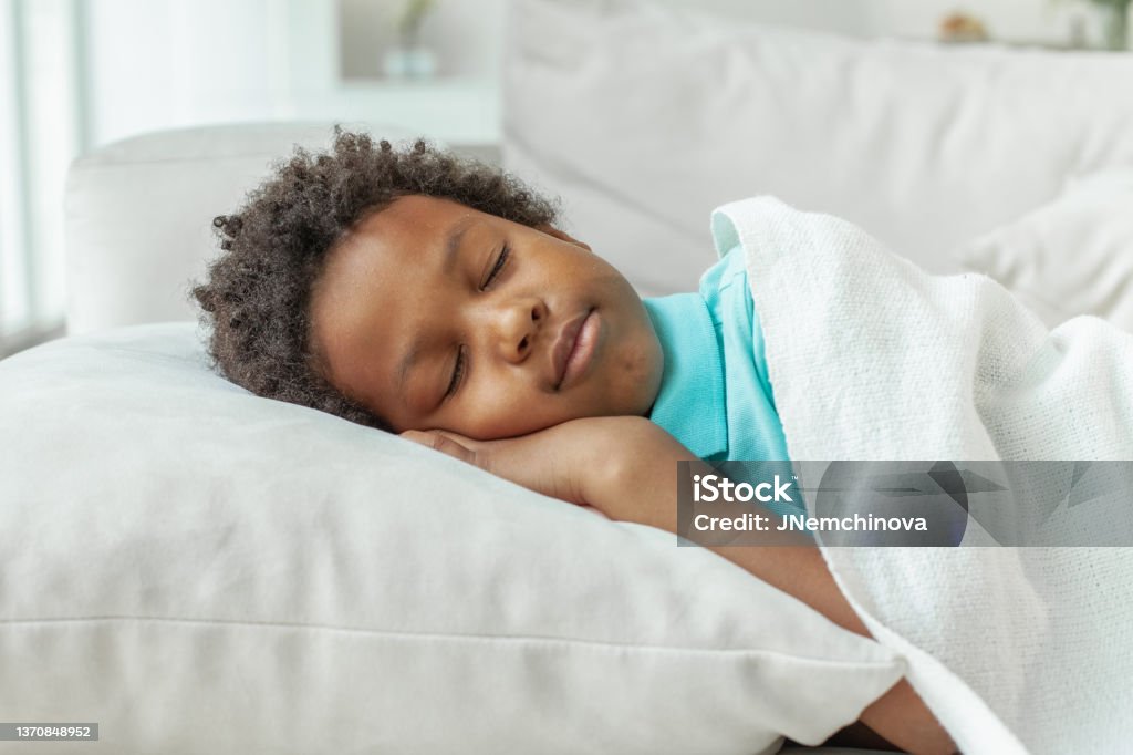 Cute little African American boy child sleeping in bed Sleeping Stock Photo