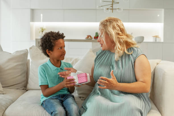 istock Child boy offering a gift to their mother at home 1370848984
