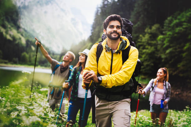 Group of happy friends with backpacks hiking together stock photo