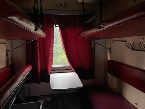 Inside train. View of the compartment of a reserved seat carriage. The interior of typical Ukrainian cheap couchette compartment, with the beds folded down to the night-time configuration. The cheaper 