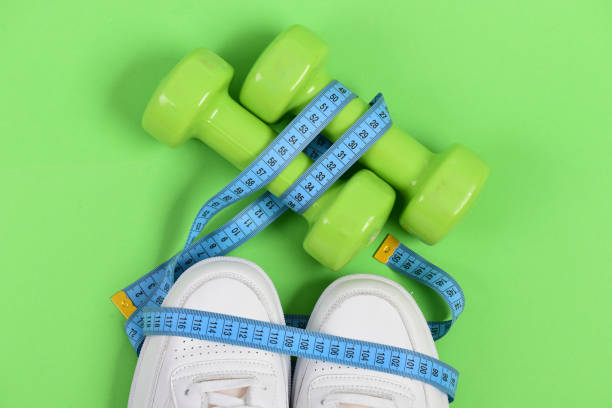 istock Centimeter in cyan blue color on white trainers and dumbbells 1370857984