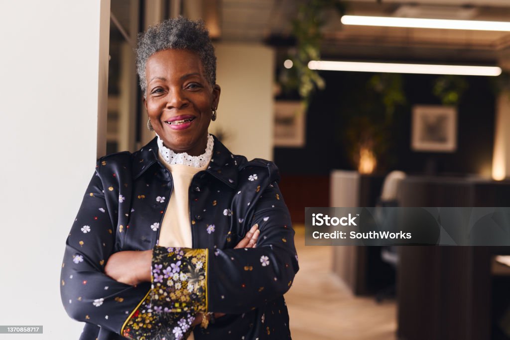 Portrait of confident senior black woman smiling and looking at camera with arms folded Senior Adult Stock Photo