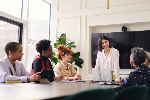 mid adult chinese woman in business meeting with multi ethnic colleagues - leadership business women senior adult imagens e fotografias de stock