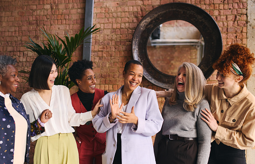 Retrato del Día Internacional de la Mujer de alegres empresarias multiétnicas de rango mixto celebrando photo