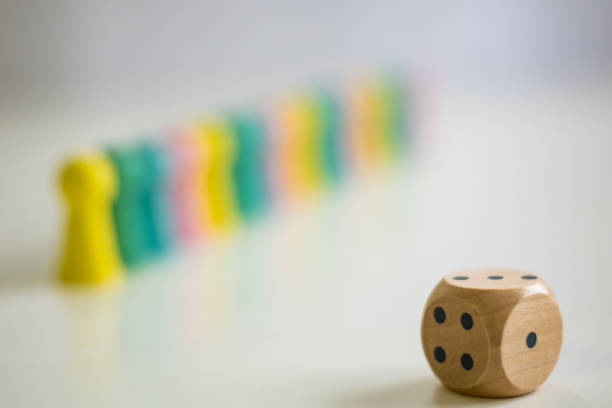 istock Dice and blurred pawns in background 1370859068