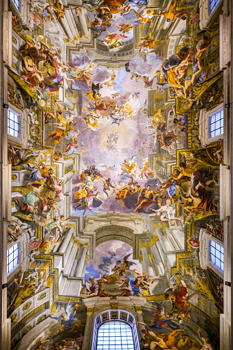 The majestic and stunning vault frescoed by the artist and religious Andrea Pozzo (1642-1709) along the main nave inside the church of Sant'Ignazio di Loyola (St. Ignatius of Loyola), in the historic heart of Rome. These wonderful frescoes, a late Baroque masterpiece made in 1685, represent the Apotheosis of Ignatius, icon of the Jesuit missionary spirit, simulating the perspective of a second roofless church, set between the clouds and the sky. In 1980 the historic center of Rome was declared a World Heritage Site by Unesco. Super wide angle image in high definition format.