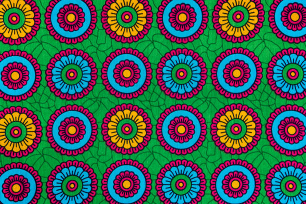 Colorful African textile close-up. Ethnic geometric pattern, fabric from Tanzania with abstract floral motifs and vibrant colors.