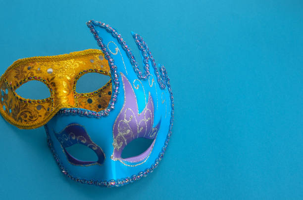 istock two carnival masquerade masks purple and yellow on a blue background copyspace. 1370861436