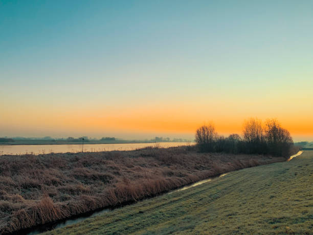 Cold winter sunrise at the river IJssel during winter near Kampen in Overijssel, Netherlands.