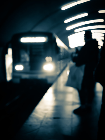 Blurry image of a platform with passengers waiting for the train.