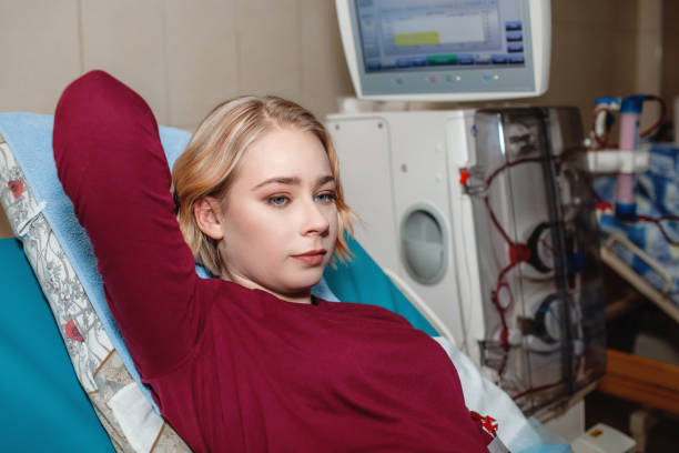 Young girl on hemodialysis in hospital, dialysis system equipment, kidney disease chronic patient Young beautiful girl, during hemodialysis in hospital, dialysis system equipment, habitual routine for chronic patient, lifestyle, medical concept peritoneal dialysis stock pictures, royalty-free photos & images