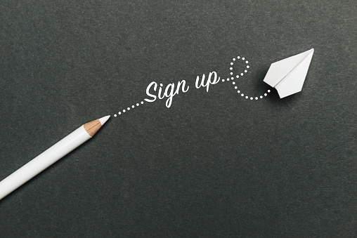 White pencil with Sign Up text and a white paper plane on black background.