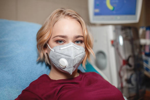 Young girl on hemodialysis in hospital, dialysis system equipment, kidney disease chronic patient Portrait of young beautiful girl in medical mask on hemodialysis in hospital, dialysis system equipment, habitual routine for chronic patient, lifestyle, medical concept peritoneal dialysis photos stock pictures, royalty-free photos & images
