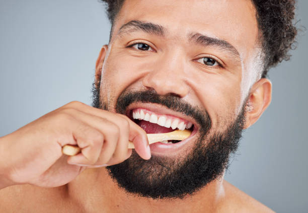 istock Studio portrait of a handsome young man brushing his teeth against a grey background 1370864999
