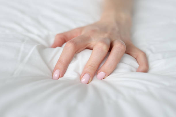 istock A woman's hand is squeezing a blanket on the bed 1370865978