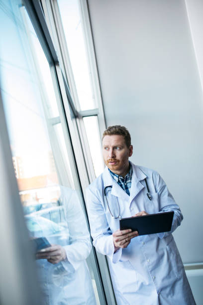 Young worried doctor looking at the results stock photo