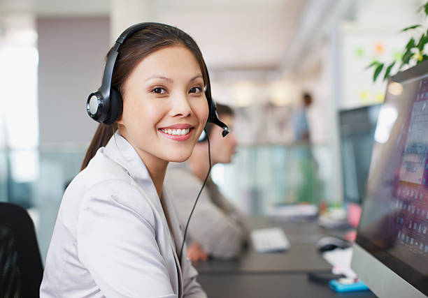 retrato de empresaria sonriente con auricular en computadora en de - women on the phone headset service fotografías e imágenes de stock